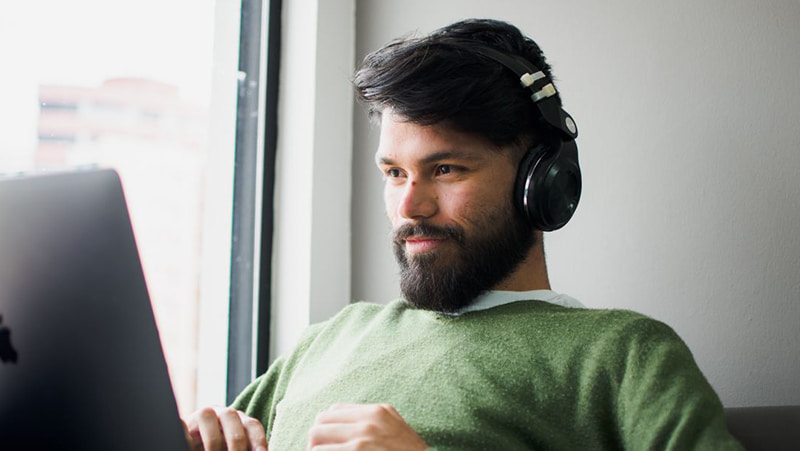 Image- A guy on headset and using laptop- 1800px