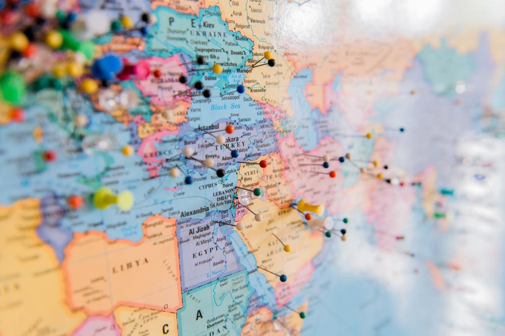 Image of a map of the world with pins pushed into various countries