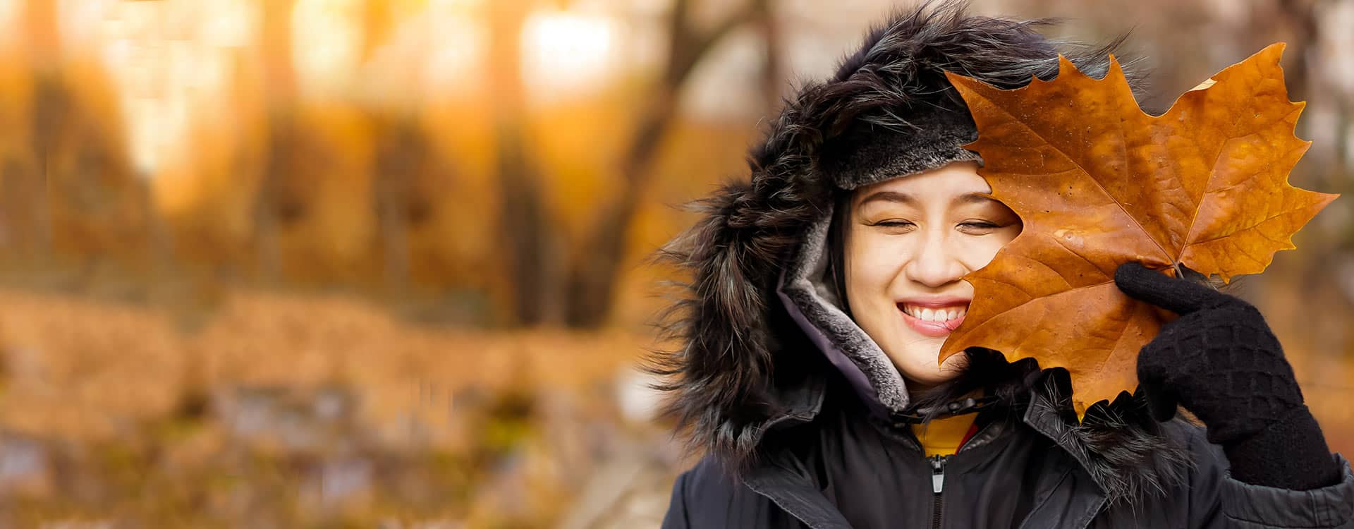 Woman smiling holding maple leaf