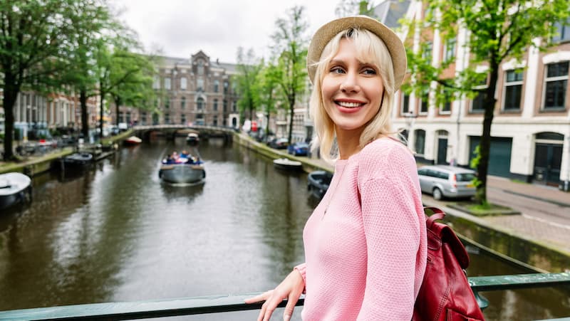 Woman smiling next to the canal in Amsterdam